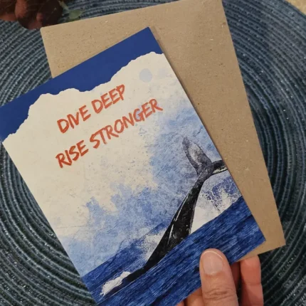 A premium Eco-Friendly Greeting Card featuring a black whale tail fluke and the text "Dive Deep, Rise Stronger" in orange.