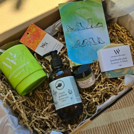 Overhead view of a sustainable Australian gift box containing Perfect Potion Green Goddess lotion, Lemon Myrtle bath bomb, and Wheelers Hill handmade soap on brown crinkle paper.