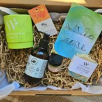 Overhead view of a sustainable Australian gift box containing Perfect Potion Green Goddess lotion, Lemon Myrtle bath bomb, and Wheelers Hill handmade soap on brown crinkle paper.