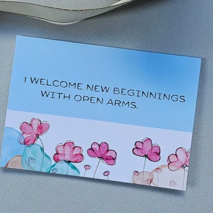 New Beginnings Greeting Card with pink watercolor flowers on a blue and white background