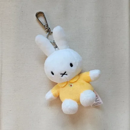 Close up of a handmade rabbit keychain showing the soft organic fabric and silver clasp.