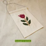Handmade embroidered flower wall hanging on natural fabric background